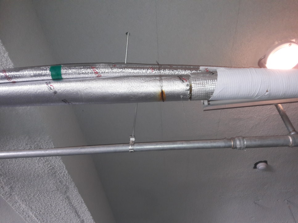 실내 천장에 설치된 금속관과 조명