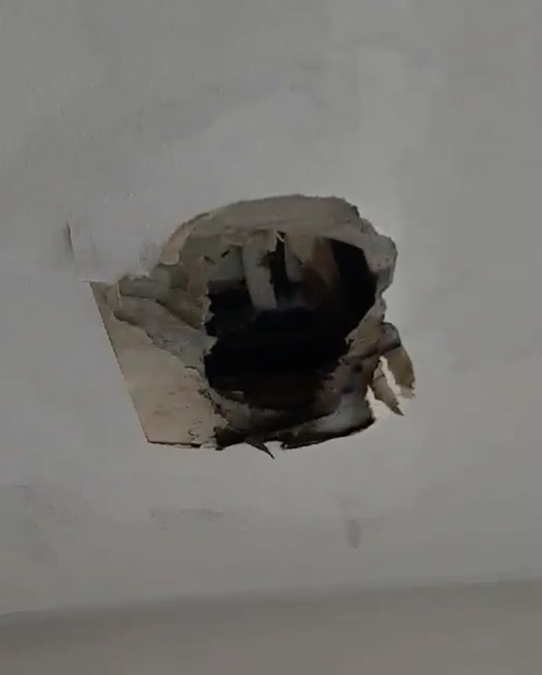 마감 가장자리가 불규칙하게 떨어져 내부가 드러난 천장 구멍
