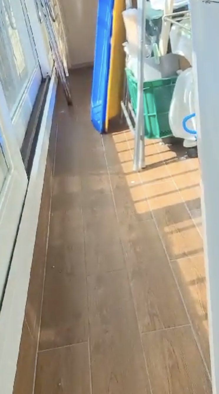 창호 옆 갈색 타일 베란다 통로와 수납 선반