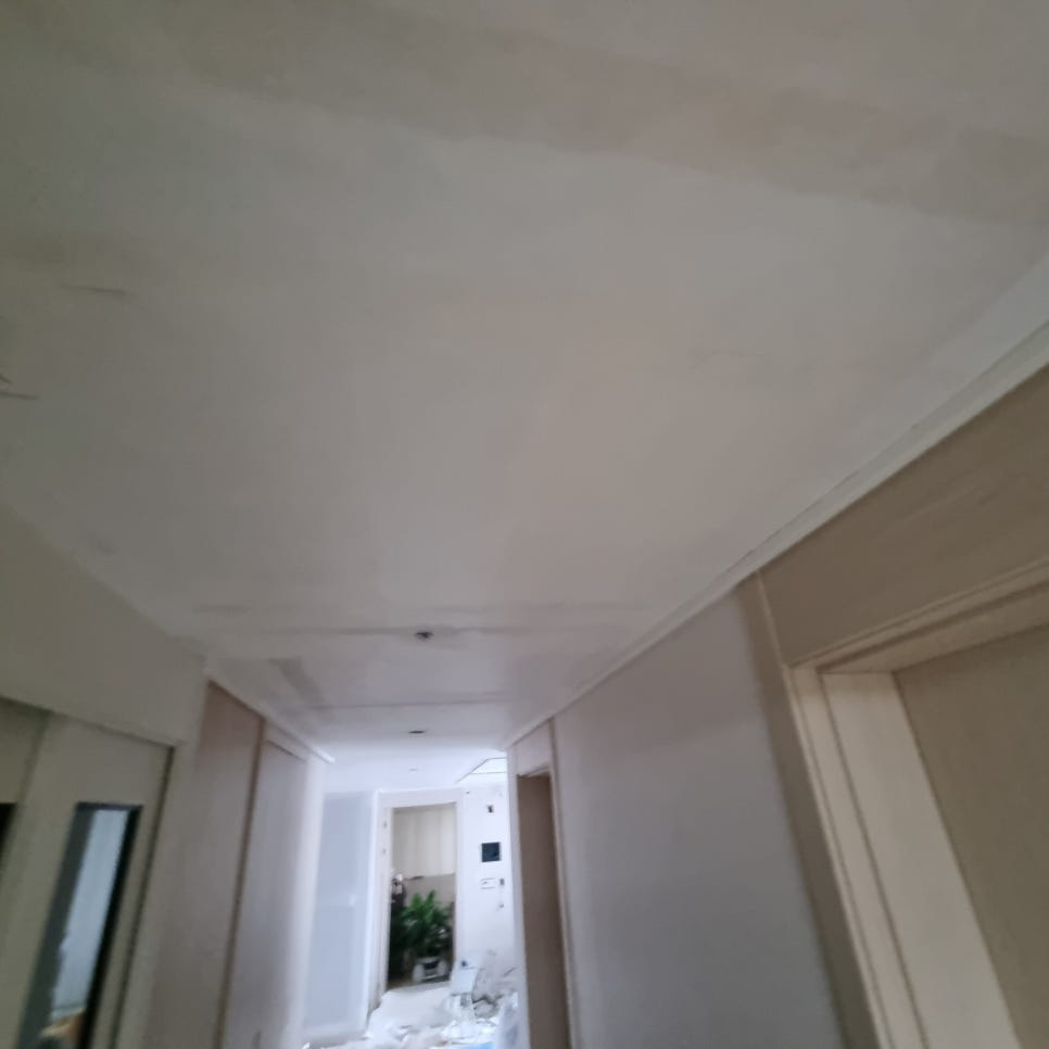 흰 면과 띠 모양 경계가 이어진 복도 천장과 바닥의 잔재