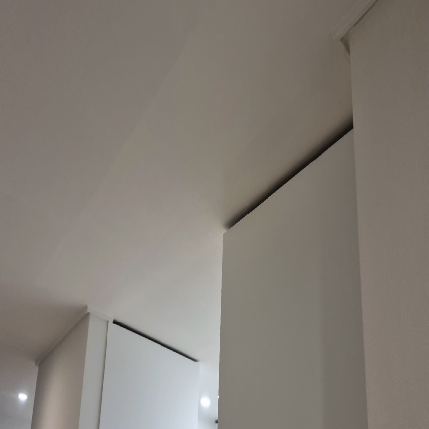 수납장 상단을 따라 어두운 선이 보이는 흰 천장