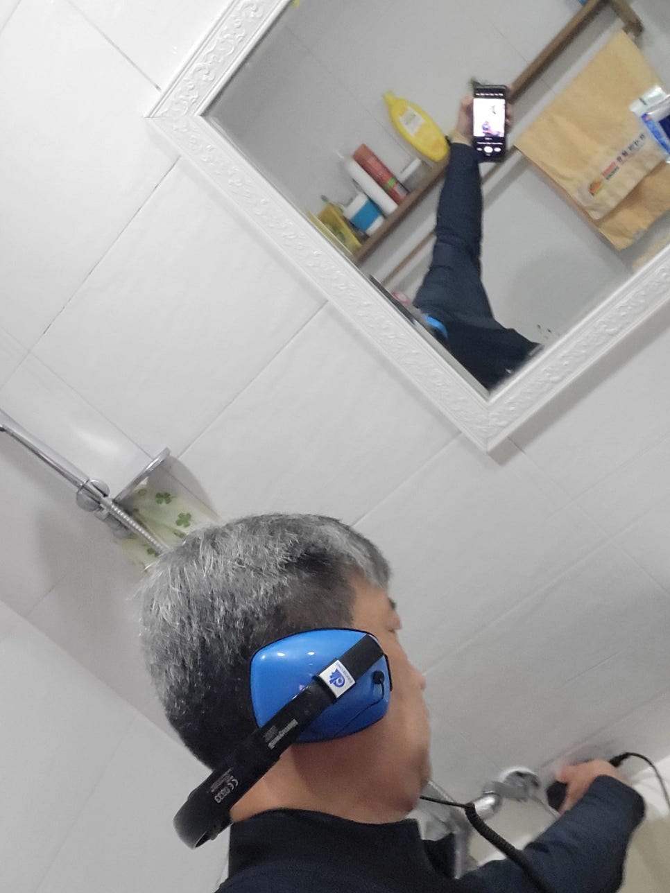 욕조 수전 옆에 유선 장치를 대고 점검하는 작업자