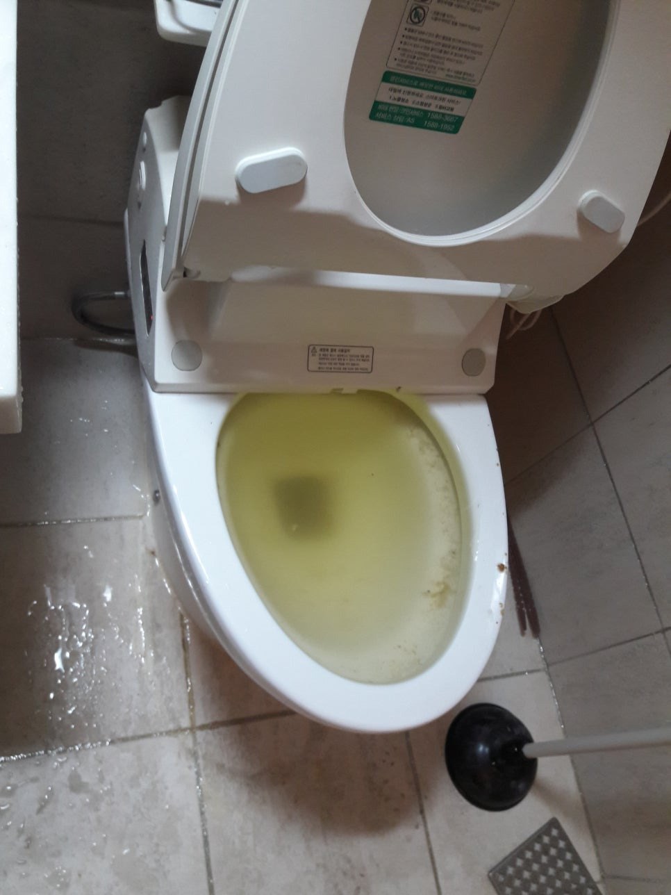 탁한 물이 높게 고인 변기와 바닥 물기