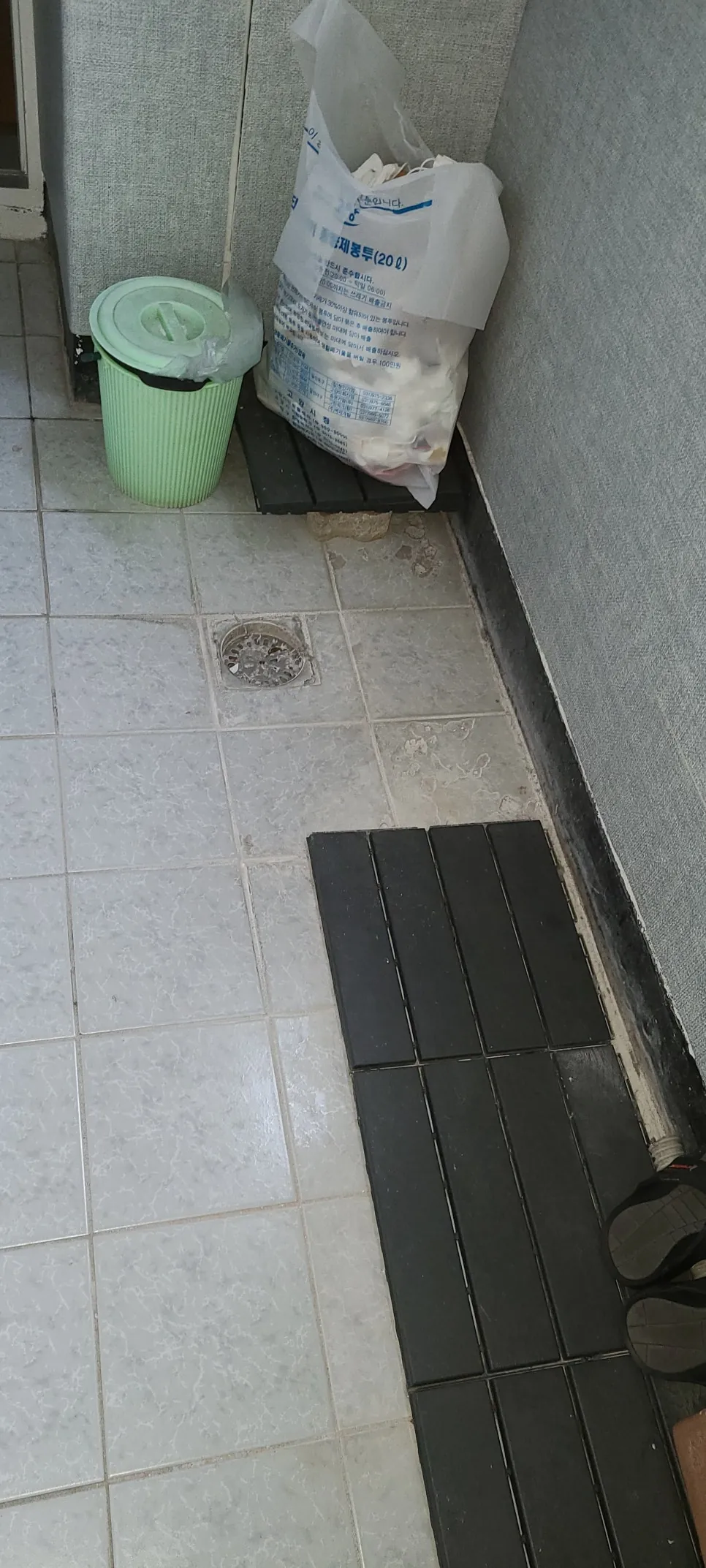 베란다 타일 바닥과 검은 깔판